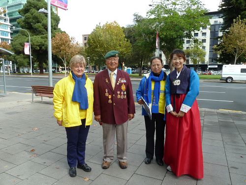 澳紐軍團日遊行的韓裔老兵Yun Lee支持法輪功，和學員合影。