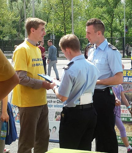 在法輪大法展位的右邊是波蘭警察學會展位，警察們聽真相後都在徵簽簿上簽名