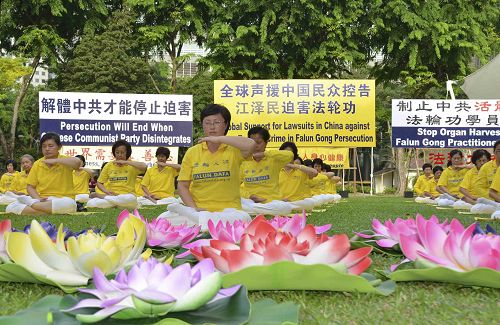 圖1－2：反迫害十六週年，新加坡法輪功學員在芳林公園舉辦活動，傳播法輪功真相，並將「訴江大潮」廣告民眾。