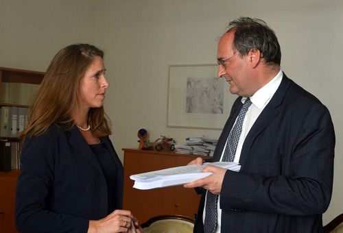 圖2：DAFOH代表Katja Hausmann （左）向人權專員Gerhard Doujak博士（右）遞交一年來收集到的兩百多萬簽名支持「制止強摘法輪功學員器官」的徵簽副本。