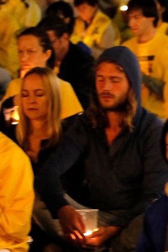 圖4：奧地利大學生Michael Hofer和Julia Gegenhuber走進燭光場地，和法輪功學員坐在一起，表達他們的支持。