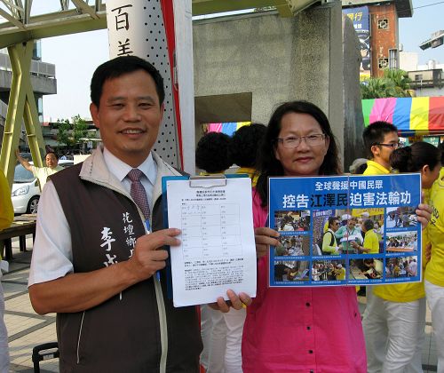 圖1：花壇鄉鄉長李成濟（左）在彰化火車站前的聲援訴江活動中，簽下舉報江澤民聯署書，並開心地展示。