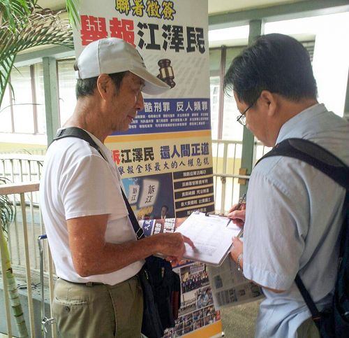 法輪功學員向簽名舉報江澤民的香港市民講真相。