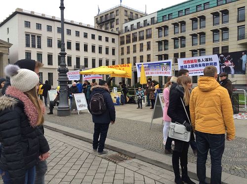 '圖2：十二月十日，柏林法輪功學員在勃蘭登堡門前向柏林市民和來自世界各地的遊客展示法輪功功法，很多人觀看。'
