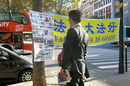圖4-8 ：來巴黎旅遊的中國大陸遊客經過世界著名的埃菲爾鐵塔附近的法輪功真相點時，許多人駐足閱讀真相展板，了解真相。