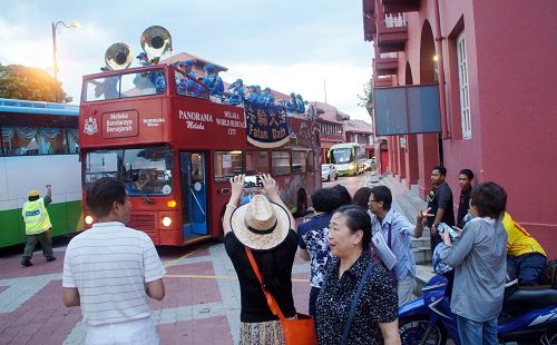 中國遊客驚喜民眾開心看到天國樂團在荷蘭紅屋廣場演奏，抓緊時間拍照、攝影留念。