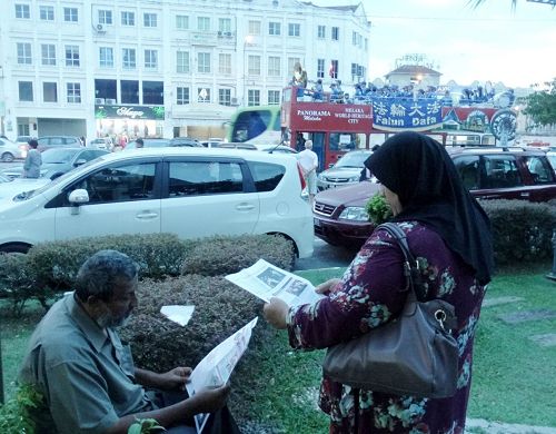 退休商人Kasim 與太太正在專注的閱讀真相資料。