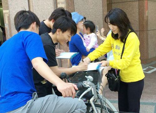 圖1-2：日本法輪功學員在福岡天神徵集聲援起訴迫害元凶江澤民的簽名。許多民眾簽名後，並對法輪功學員說：我們支持你們。