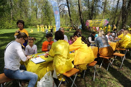 圖10：莫斯科庫斯明克公園裏歡慶法輪大法日的活動中，小朋友學疊紙蓮花