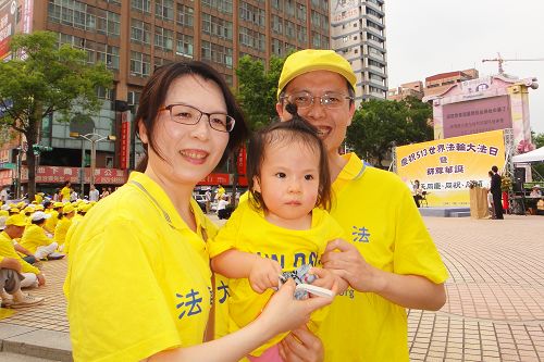 圖9：韋志龍帶著妻子及一歲多的女兒參加世界法輪大法日活動。