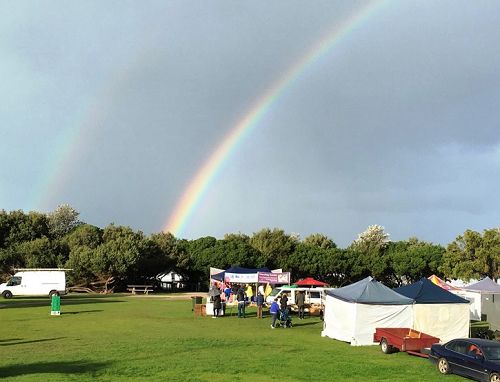 當天下午，在「法輪大法好」展位背後的天空，出現了雙彩虹。