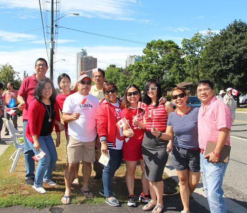 Edward（右一）和他的菲律賓社團成員在觀看遊行，他們表示，我們都支持法輪功！