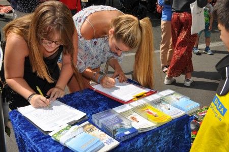 兩位年輕女士在徵簽表上簽名，支持法輪功學員。