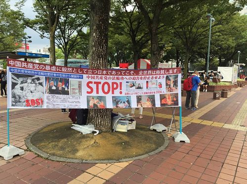 '圖1：法輪功學員在日本名古屋繁華街邊一角，掛起了反迫害的條幅'