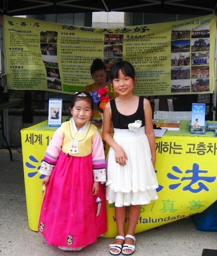 '圖11：韓國小姐妹Victoria（右）和Kate（左）：我們喜歡法輪大法，也喜歡小蓮花。'