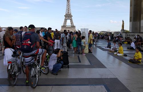 圖1：巴黎人權廣場上，遊客觀看法輪功學員演示功法