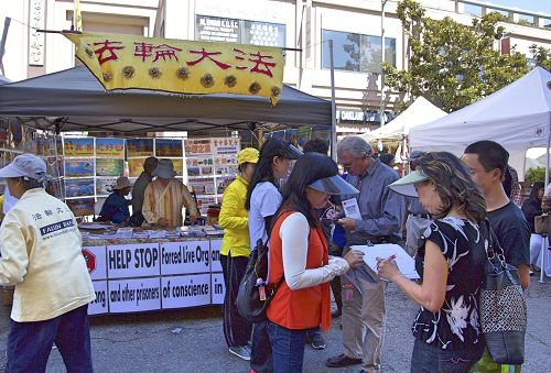 '圖1-2：加州舊金山灣區法輪功學員在奧克蘭市一年一度的中秋街會設立展位，向民眾傳播法輪功真相。許多民眾主動簽名支持法輪功學員反迫害。'