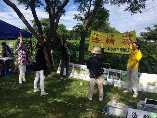 圖1-2：在稻澤夏季活動節展位上學煉法輪功的市民們
