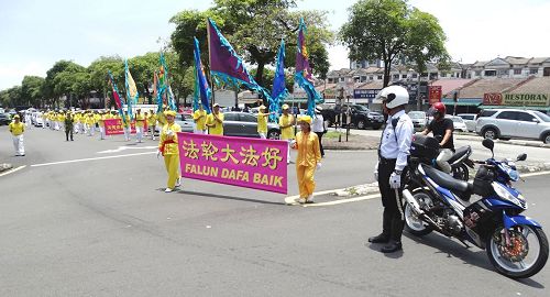 '圖6：馬來西亞法輪功學員來到雪蘭莪州班丹英達（Pandan Indah）舉辦慶中秋遊行活動，交通警察和自願警衛隊前來提供協助，為法輪功遊行隊伍開路。'