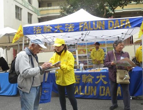 '圖1：二零一六年九月十日和十一日，法輪功學員在舊金山中國城的「中秋街會」上設立展位，向民眾講述法輪功的真相，並徵集「制止中共活摘」的簽名。許多華人簽名支持。'