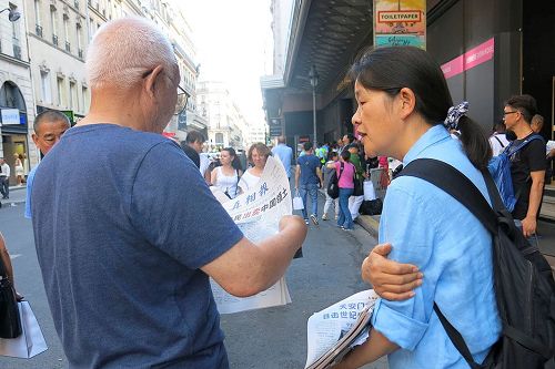 '圖1：退黨義工在向巴黎拉法耶特商店門前的大陸遊客講真相。'