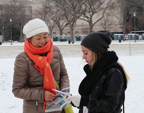 '圖01：二零一七年一月七日下午，華府法輪功學員李女士在美國國家廣場向過往遊客傳遞真相。'
