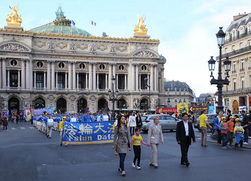 '圖3：奧斯塔麗女士全程參加了法輪功學員的集會與遊行，並一直走在遊行隊伍的最前面。圖為遊行隊伍經過巴黎歌劇院（Opéra Garnier）。'