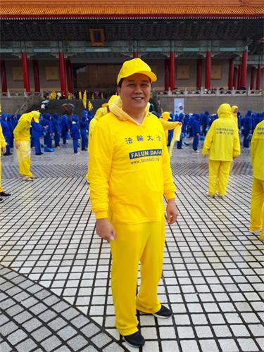'修煉心得交流會前夕，陳昱熾參加在台北自由廣場舉行的大型排字及集體煉功活動。'