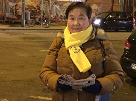'圖4：法輪功學員文女士在法蘭克福街頭給中國遊客發關於法輪功的真相報紙。'