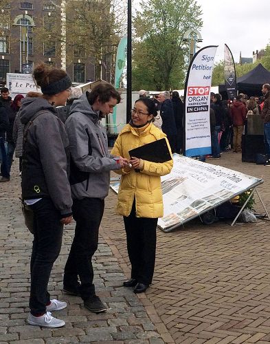 在荷蘭阿姆斯特丹唐人街，路人駐足聽法輪功學員講真相