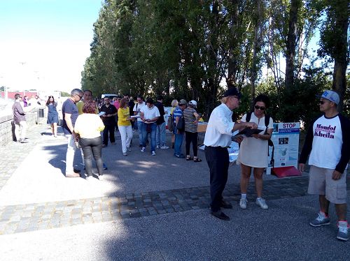 '圖1，葡萄牙法輪功學員在里斯本世博會公園舉辦活動講真相，慶祝世界法輪大法日'