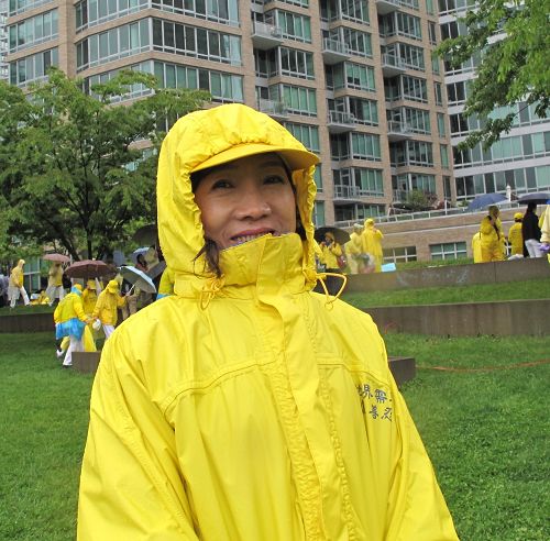 圖：來自台北的李素明女士在紐約甘純公園（Gantry Park）冒雨參加「大法洪傳25 years」大型排字