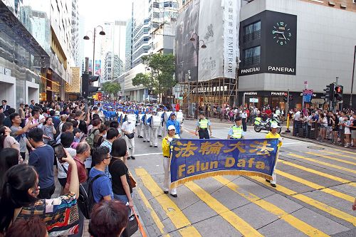 '圖6～11：法輪功學員遊行慶祝「世界法輪大法日」，及「法輪大法弘傳世界二十五週年」紀念，吸引香港市民及中西遊客駐足關注及拍照。'