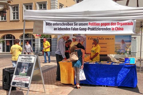 '圖2：二零一七年六月三日，德國西南部萊茵蘭-普法爾茨州的法輪功學員在酒路新城（Neustadt an der Weinstrasse）舉辦信息日，傳播法輪功的真相，同時徵集「反對中共強摘器官」的簽名。'