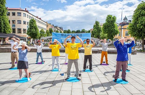 '圖1：二零一七年六月十七日，瑞典法輪功學員在厄勒布魯（Örebro）市中心廣場上舉辦法輪大法信息日活動。圖為法輪功學員正在演示第二套功法──法輪樁法。'