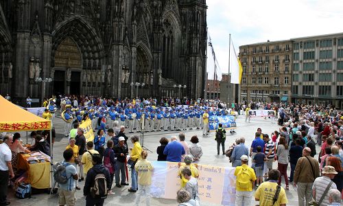 法輪功學員組成的天國樂團在科隆大教堂前表演，吸引了眾多遊客。