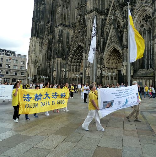 法輪功學員在科隆舉辦遊行，背景是著名的科隆大教堂。