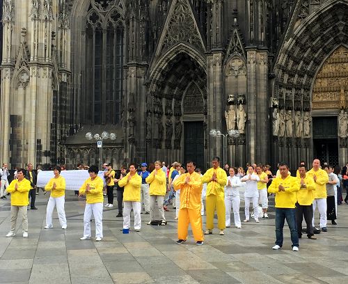 法輪功學員在科隆大教堂前演示功法。