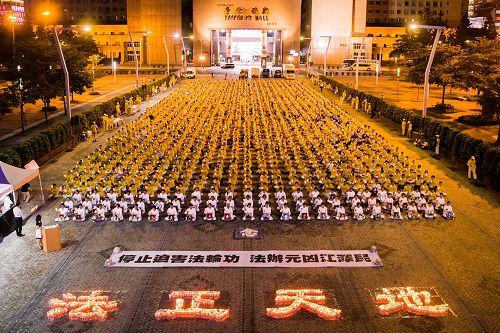 '圖1：法輪功學員在台北市政府廣場前舉辦反迫害18週年燭光悼念活動。'