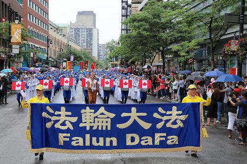 '法輪大法天國樂團，和旌旗、煉功隊伍的法輪功學員共250多人應邀參加了蒙特利爾7月1日舉辦的加拿大國慶遊行，受到東、西方觀眾盛讚。'