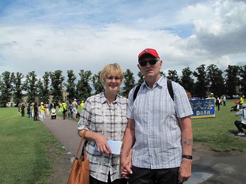'圖3：從多賽特（Dorset）來劍橋遊覽的雪莉（Shirley）和伊恩（Inn）夫婦站在即將出發的法輪功學員遊行隊伍前'