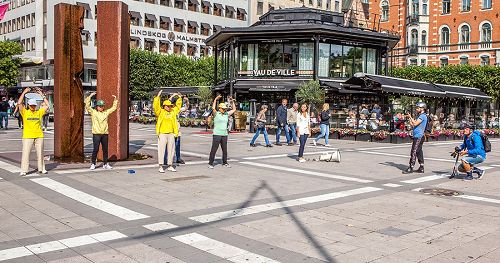 '圖1：在瑞典文化節期間，法輪功學員在斯德哥爾摩的北城廣場（Normalmstorget）設立真相點向民眾介紹法輪大法的真相。圖為學員們正在展示法輪功的第二套功法──法輪樁法。'