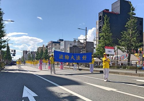 '圖1～2：日本法輪功學員首次參加久留米市舉辦水之慶典遊行，把法輪大法美好帶給久留米市民。'