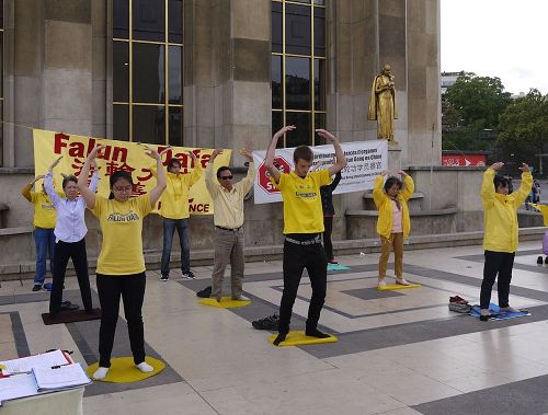 '圖1：法輪功學員在艾菲爾鐵塔下的人權廣場演示功法'