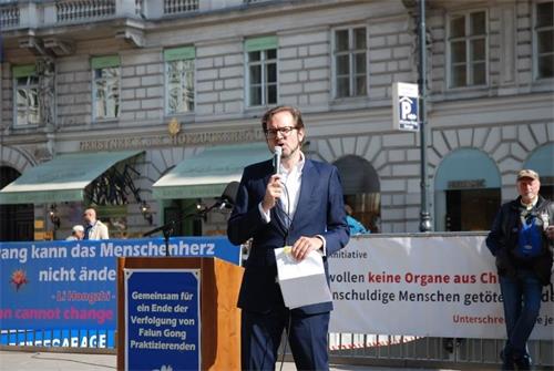 '圖7：集會主持人弗洛裏安（Florian）告訴駐足的民眾甚麼是法輪功，以及今天歐洲各國法輪功學員在維也納集會的意義。'
