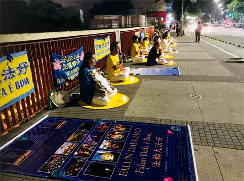 '圖4：法輪功學員在自由大道上點燃蠟燭，肅穆靜坐，悼念被中共迫害致死的中國法輪功學員。'
