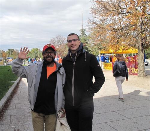'圖6：來自中美洲的卡洛斯（Calros，左）和朋友看到法輪功真相後主動向站在路邊的法輪功學員表示支持'