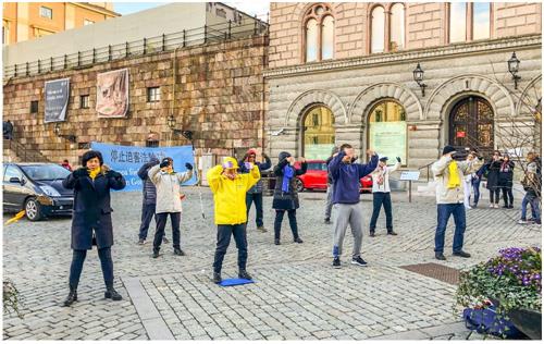 '圖1：法輪功學員在斯德哥爾摩市中心皇宮旁的錢幣廣場舉辦講真相活動。'