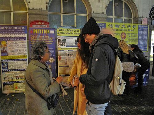 '圖8：十一月十七日，兩位意大利遊客在倫敦唐人街第一次聽說法輪功，了解真相後立即簽名反迫害。'