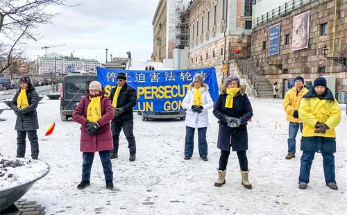 '圖1：法輪功學員們冒著嚴寒在斯德哥爾摩市中心皇宮旁的錢幣廣場上舉辦講真相活動。'